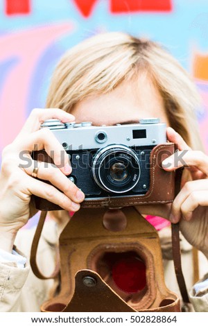 Girl with retro camera on the colorfull background