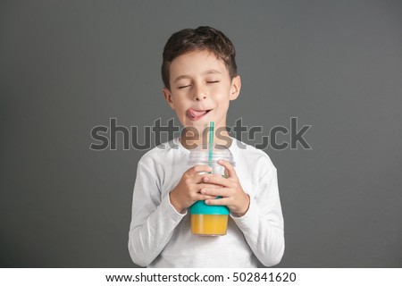 Little funny boy drinking a fresh juice through a straw Royalty-Free Stock Photo #502841620