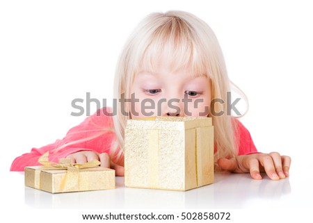 cute girl looking into a golden gift box isolated on white