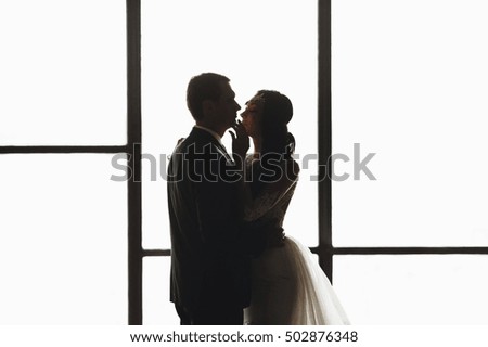 man and woman standing in the background of a big window