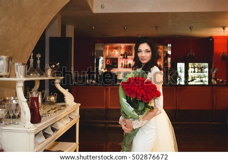young bride holds many roses in hands