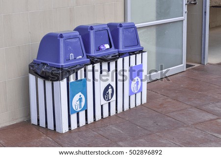 A blue recycling bin on floor