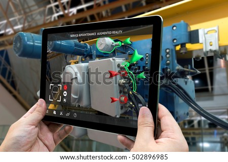 Industrial 4.0 , Augmented reality concept. Hand holding tablet with AR service , maintenance application and calling technician for check destroy part of smart machine in smart factory background Royalty-Free Stock Photo #502896985