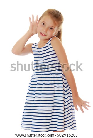Caucasian little girl in a striped summer dress, listening. Girl holding a hand to his ear.Isolated on white.