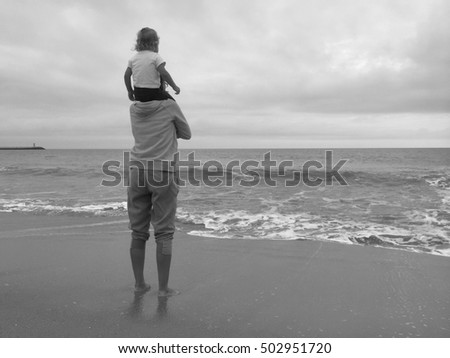 Back view of mother with child on beach dark cloud sky outdoors background. Book cover idea design style