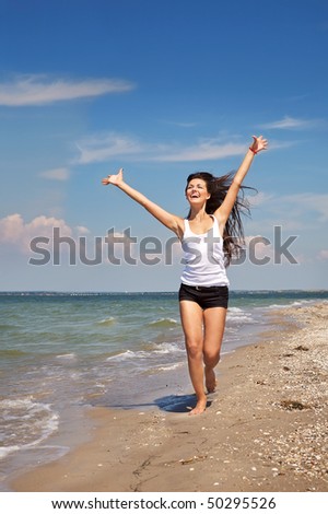 Picture of the beautiful ecstatic girl running  on the beach