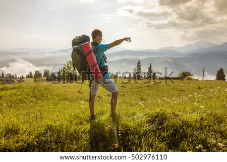 Hiker with a backpack standing in mountains