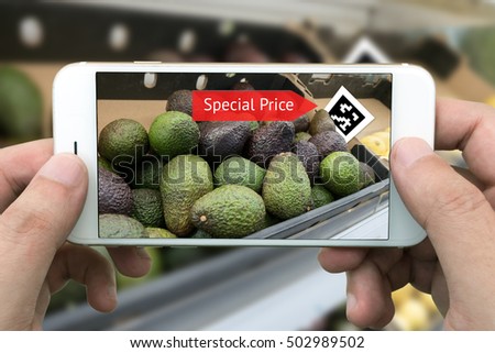 Augmented reality marketing concept. Hand holding smart phone use AR application to check sale special price of avocado in retail store or fruit market mall