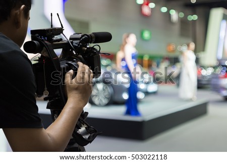 Covering an event on stage with a video camera. Royalty-Free Stock Photo #503022118