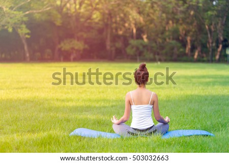 Young Asian woman practicing yoga pose at the park , yoga and meditation have good benefits for health. Photo concept for Yoga Sport and Healthy lifestyle. Royalty-Free Stock Photo #503032663