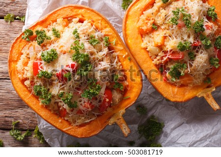 Baked pumpkin stuffed with couscous, meat and vegetables close-up on the table. horizontal view from above