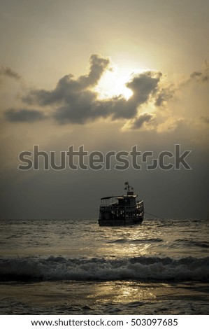 Silhouette boat on the beach at sunrise
