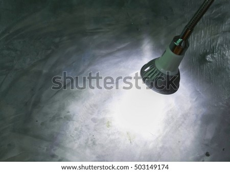 Light from the lamp on the cement walls.