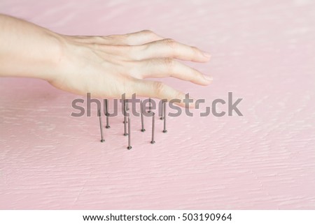 Close up woman hand on danger nails,Woman hand about to step on nails.
