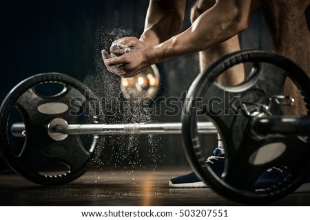 Sports background. Young athlete getting ready for weight lifting training. Powerlifter hand in talc preparing to bench press Royalty-Free Stock Photo #503207551