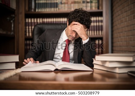 Portrait of a tired businessman reading a book