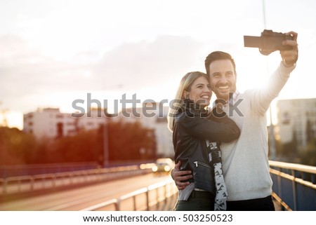 Tourist couple taking selfies during sunset