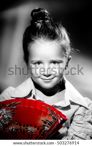 Cute little girl portrait with red hand-fan, retro style