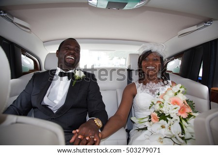 Beautiful young couple smiling happily on wedding-day, sitting in limousine. Royalty-Free Stock Photo #503279071