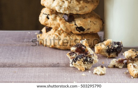 Closeup of pile made from homemade moms chocolate cookies and glass of milk on wooden background