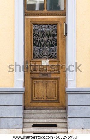 View on a wooden door with a small shield reading welcome to our happy home.
