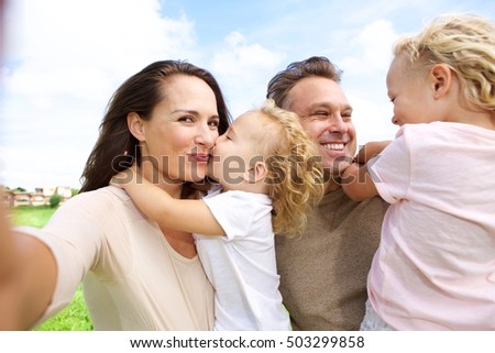 Portrait of woman talking selfie of her family outdoors