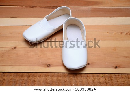 Gymnast's toe shoes on wooden floor