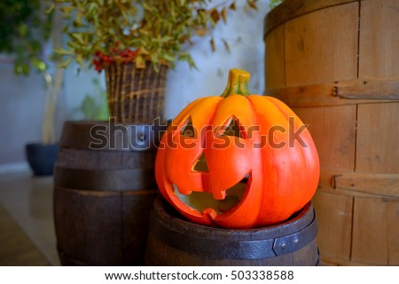 Halloween pumpkin head jack lantern on wooden barrel