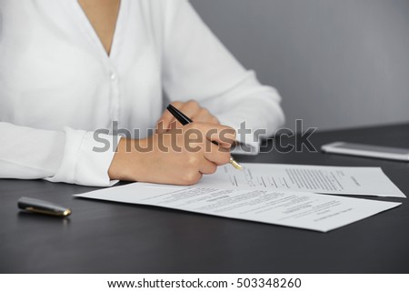 Woman signing last will and testament, closeup