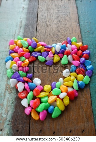 small color stone picture Heart, small color rock on wood table