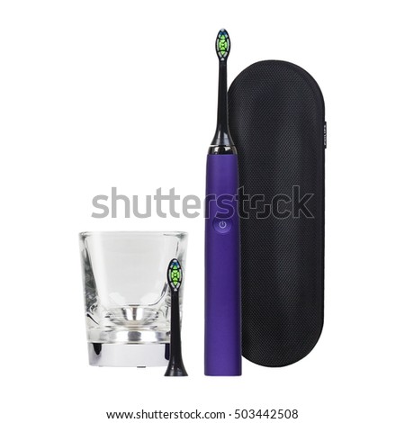 Electronic toothbrush with case, replacement brush head and glass isolated on a white background