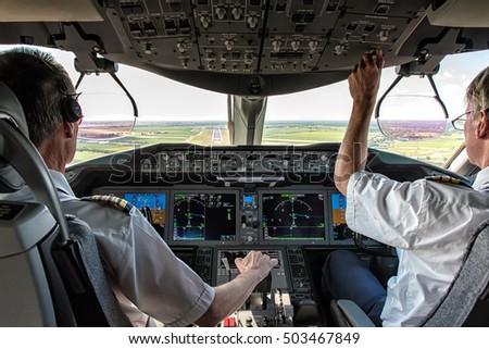 Pilot and copilot in commercial plane in cockpit, Pilot operation with control panel. Royalty-Free Stock Photo #503467849