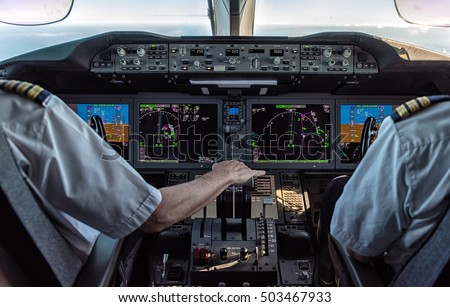 Pilot and copilot in commercial plane in cockpit, Pilot operation with control panel. Royalty-Free Stock Photo #503467933