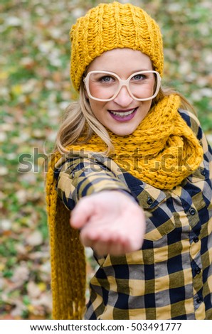 hipster girl with glasses and a cap gives a hand of support or assistance