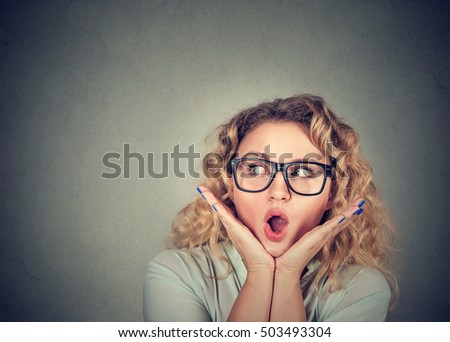 Wow. Closeup portrait young woman beautiful girl with long hair looking excited holding her mouth opened, hands on head isolated on gray wall background. Shocked surprised stunned. Human emotions