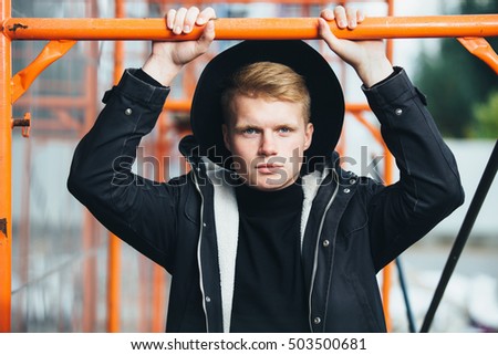 Young man posing with a trendy outfit against urban background