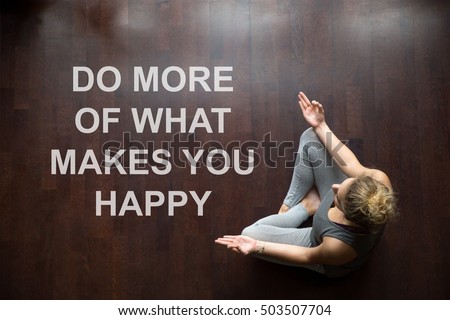 Attractive young woman working out indoors, doing yoga exercise on floor, sitting in Easy Posture, meditating, breathing, relaxing. Top view. Motivational text "Do more of what makes you happy"