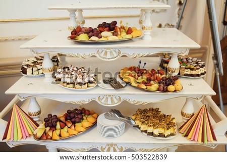 beautiful buffet table with fruit and cakes