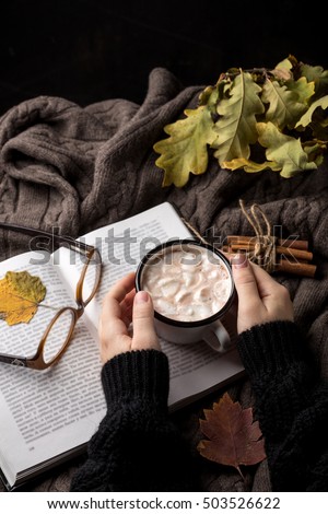 Woman holding cup of hot chocolate on dark background
