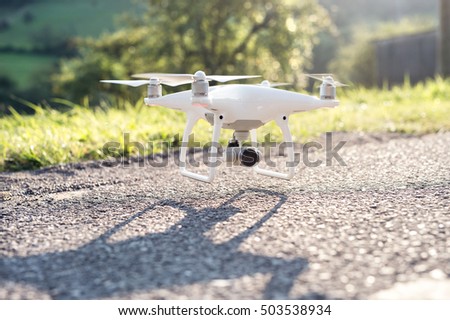 Flying helicopter drone with camera. Green sunny nature.