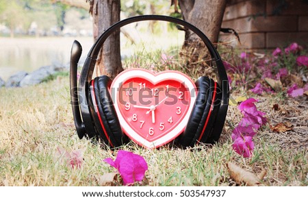 Headphones and heart clock on the grass