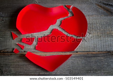 Broken heart red plate concept on wooden board