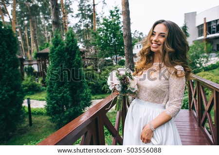 beautiful bride with white bouquet in park