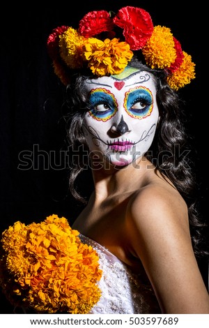 Beautiful Mexican woman with wedding dress and makeup Catrina in black background