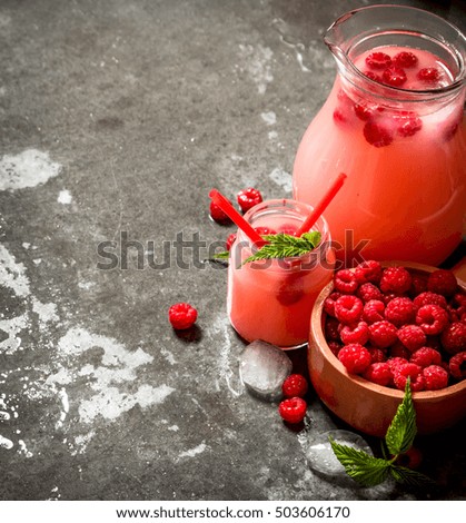 Raspberry juice with the berries and ice. On the stone table.