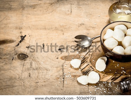 Fresh mozzarella with salt. On a wooden table.