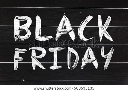 Black friday brush hand lettering on white painted rustic barn wooden planks. Greeting card or postcard.