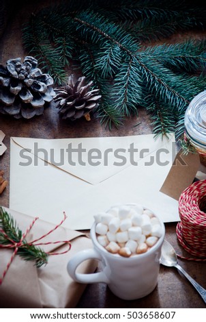 Christmas Envelope with a letter with Hot Chocolate with marshmallows and gifts decorated with pine cones and spruce branches on a dark wooden background