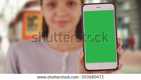 Mexican woman holding smartphone with green screen