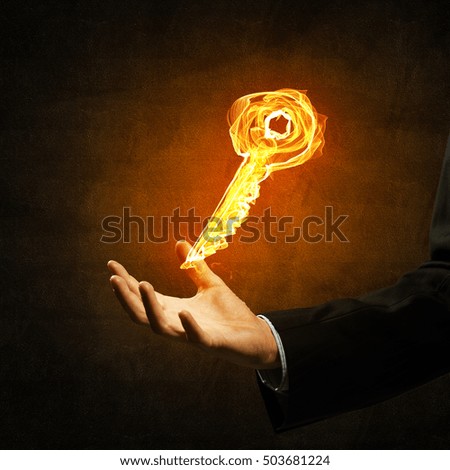 Close of businessman hand showing fire glowing key symbol